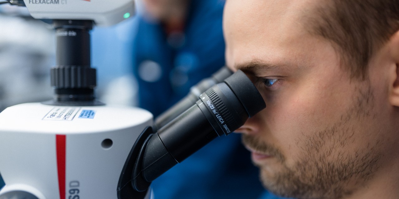 Person working with a microscope.