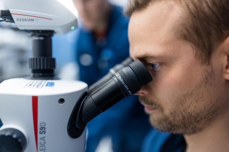 Person working with a microscope.